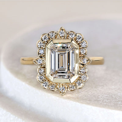 Emerald cut diamond engagement ring with bezel set yellow gold band