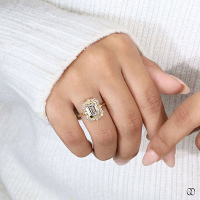 Emerald cut diamond ring with round side diamonds in yellow gold