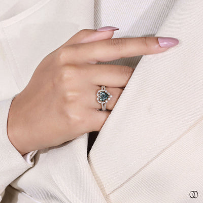 Heart shaped engagement ring with green color stone and halo