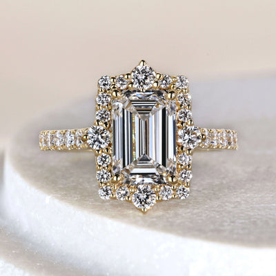 Emerald cut engagement ring in yellow gold with halo diamond ring and pave setting
