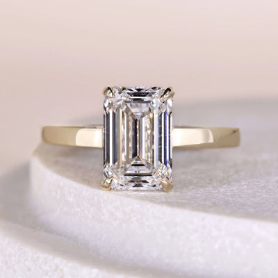 Emerald cut engagement ring with claw prong and hidden halo setting
