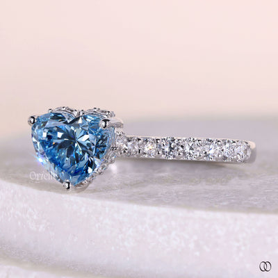 Handmade heart shaped engagement ring with blue diamond center
