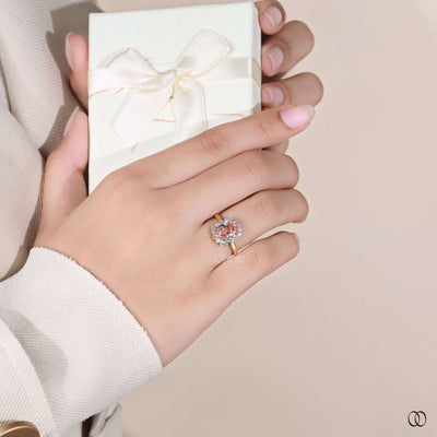 pinkish orange diamond halo engagement ring
