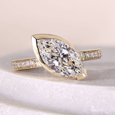 marquise cut engagement ring bezel set yellow gold
