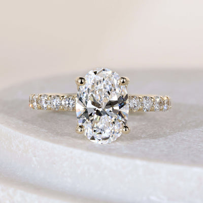 Oval engagement ring in yellow gold with pave band

