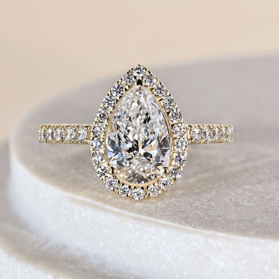 Pear cut engagement ring with pave band in yellow gold

