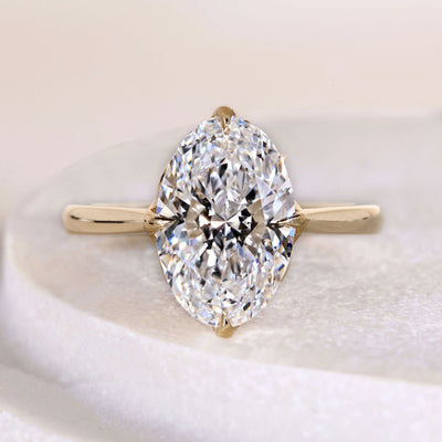 Oval cut diamond engagement ring with claw prong tulip setting in gold
