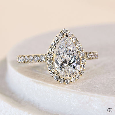 Unique engagement ring featuring pear cut diamond and halo
