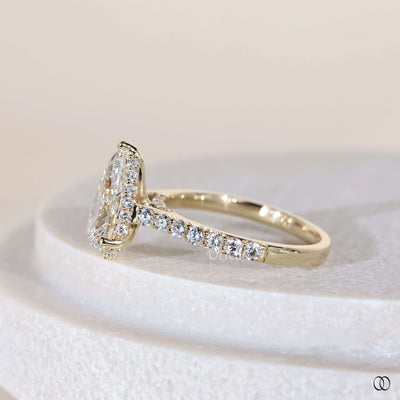Prong setting ring securing pear diamond engagement ring
