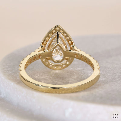 Pear engagement ring framed by round diamond halo engagement ring
