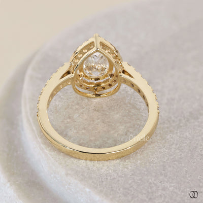 Pave engagement ring with pear cut diamond centerpiece
