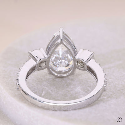 Handmade pear cut diamond ring with claw prongs and side stones
