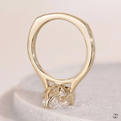 Oval solitaire diamond ring with tulip setting in yellow gold band
