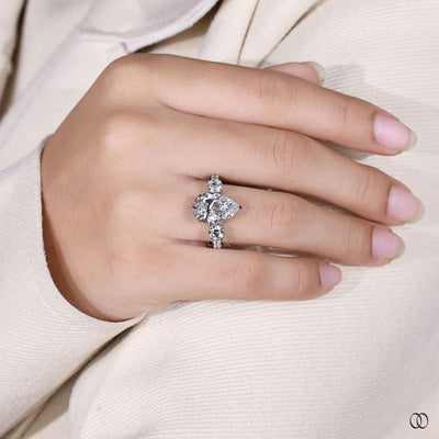White gold pear diamond engagement ring with pave diamond band
