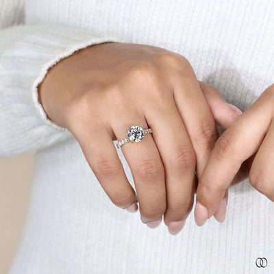 Hidden accent stone ring under round diamond setting
