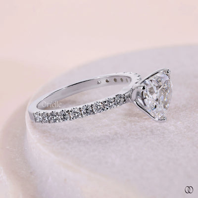 Pavé engagement ring with a brilliant diamond center stone
