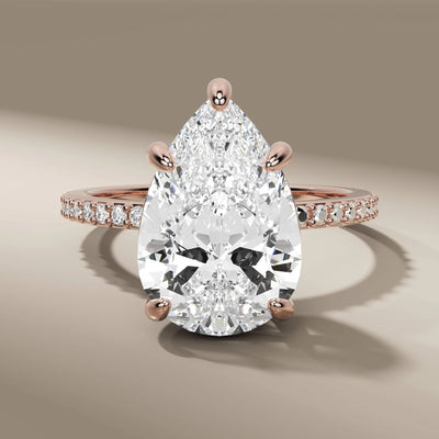 5 prong ring with pear cut diamond and side round accents
