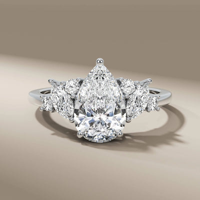 Round and marquise side stone ring in yellow gold prong setting

