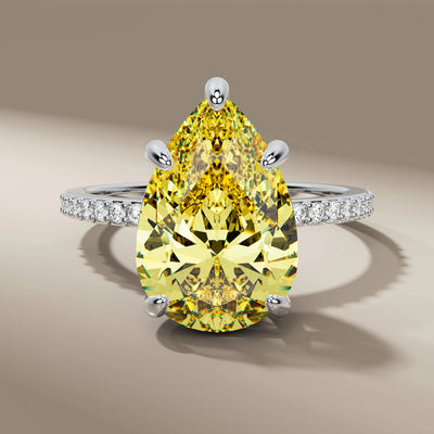 5 prong ring with pear cut diamond and side round accents
