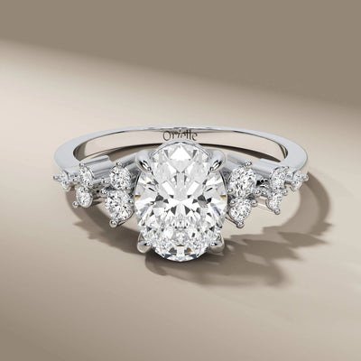 side stone engagement ring with oval center and gold band
