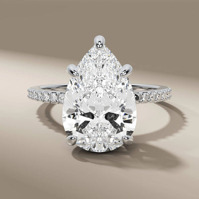 side round diamond ring paired with pear cut engagement diamond
