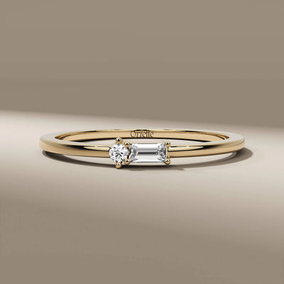 dainty engagement ring with round diamond and baguette band
