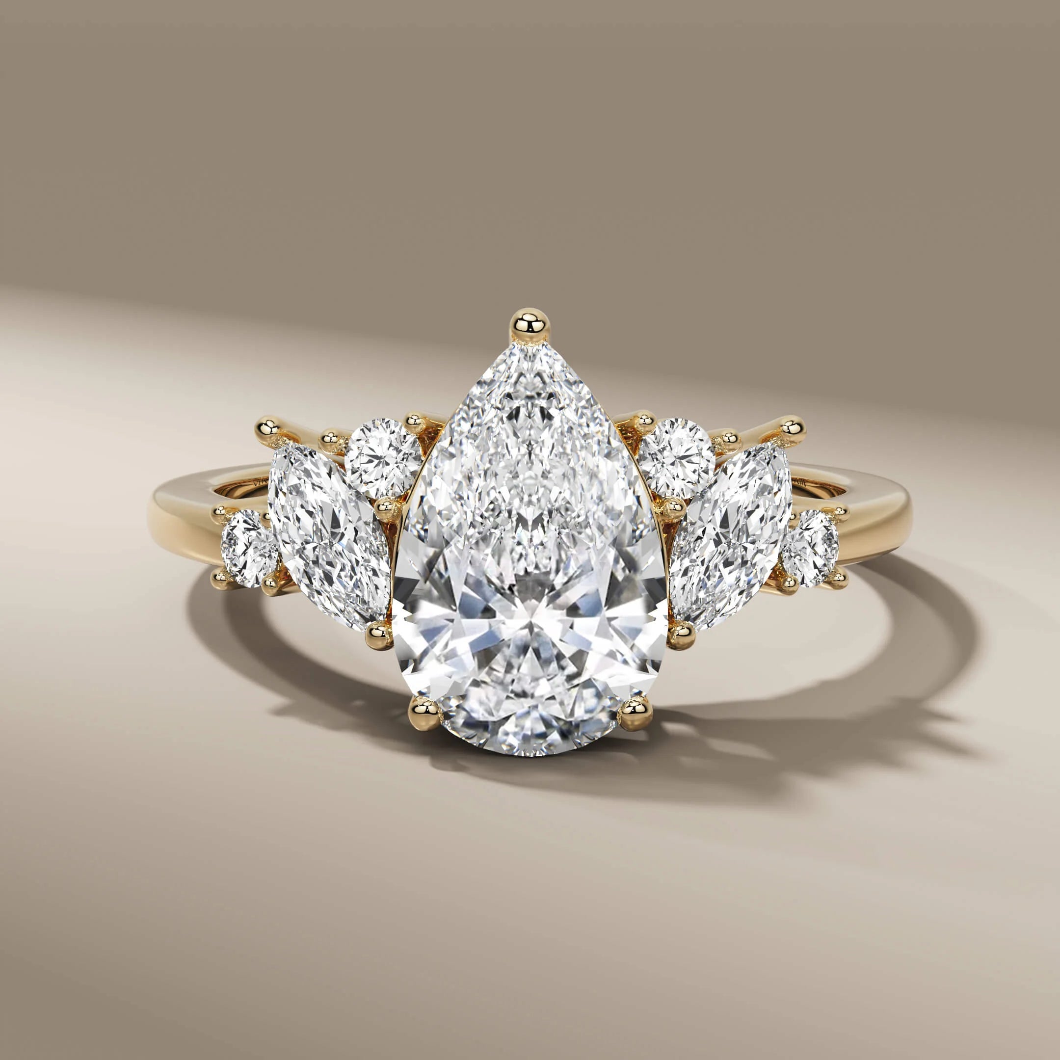 Pear cut diamond ring with round and marquise side stones in gold
