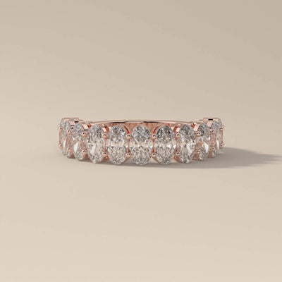 Shared prong yellow gold wedding band with oval moissanite stones
