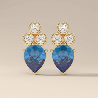 Pear cut blue sapphire earrings with bezel and prong settings
