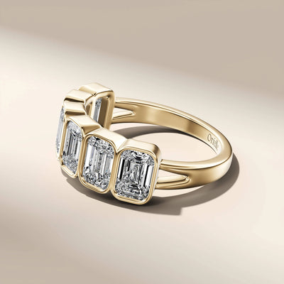 yellow gold bezel set emerald cut wedding band design
