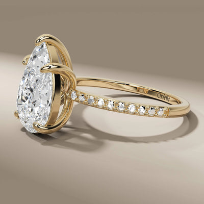 claw prong ring featuring pear cut and side round diamonds
