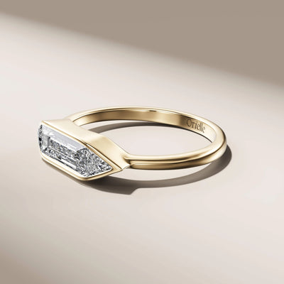 bezel set engagement ring in yellow gold with baguette diamond
